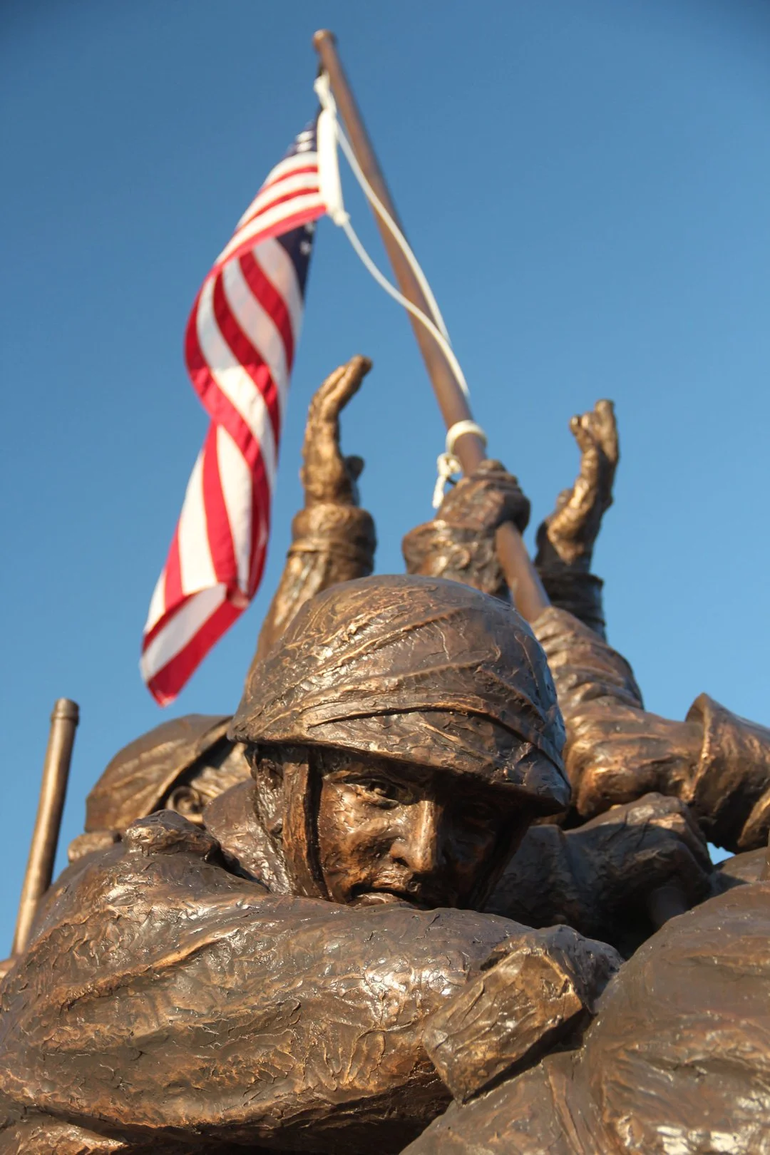 A military veteran statue holding the American flag